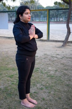 Young Indian woman practicing yoga outdoor in a park. Beautiful girl practice basic yoga pose. Calmness and relax, female happiness. Basic Yoga poses outdoor