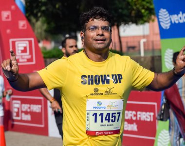 Yeni Delhi, Hindistan - 16 Ekim 2022 - Bitmek üzere olan maraton katılımcılarının bitiş çizgisini geçmek üzere olan Delhi Yarı Maratonu 2022