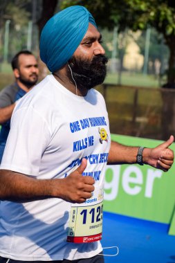 Yeni Delhi, Hindistan - 16 Ekim 2022 - Bitmek üzere olan maraton katılımcılarının bitiş çizgisini geçmek üzere olan Delhi Yarı Maratonu 2022