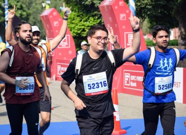 Yeni Delhi, Hindistan - 16 Ekim 2022 - Bitmek üzere olan maraton katılımcılarının bitiş çizgisini geçmek üzere olan Delhi Yarı Maratonu 2022