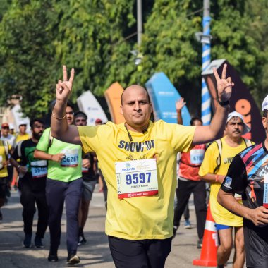 Yeni Delhi, Hindistan - 16 Ekim 2022 - Bitmek üzere olan maraton katılımcılarının bitiş çizgisini geçmek üzere olan Delhi Yarı Maratonu 2022