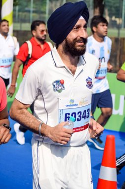 Yeni Delhi, Hindistan - 16 Ekim 2022 - Bitmek üzere olan maraton katılımcılarının bitiş çizgisini geçmek üzere olan Delhi Yarı Maratonu 2022