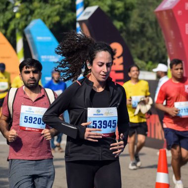 Yeni Delhi, Hindistan - 16 Ekim 2022 - Bitmek üzere olan maraton katılımcılarının bitiş çizgisini geçmek üzere olan Delhi Yarı Maratonu 2022