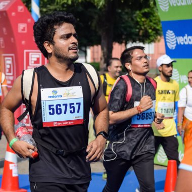 Yeni Delhi, Hindistan - 16 Ekim 2022 - Bitmek üzere olan maraton katılımcılarının bitiş çizgisini geçmek üzere olan Delhi Yarı Maratonu 2022