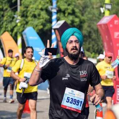 Yeni Delhi, Hindistan - 16 Ekim 2022 - Bitmek üzere olan maraton katılımcılarının bitiş çizgisini geçmek üzere olan Delhi Yarı Maratonu 2022