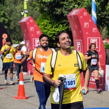 Yeni Delhi, Hindistan - 16 Ekim 2022 - Bitmek üzere olan maraton katılımcılarının bitiş çizgisini geçmek üzere olan Delhi Yarı Maratonu 2022