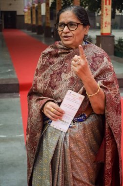 New Delhi, India - December 04 2022 - Unidentified people showing their ink-marked fingers after casting votes in front of polling booth of east Delhi area for MCD local body Elections 2022