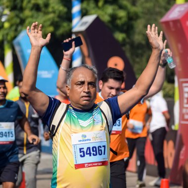 Yeni Delhi, Hindistan - 16 Ekim 2022 - Bitmek üzere olan maraton katılımcılarının bitiş çizgisini geçmek üzere olan Delhi Yarı Maratonu 2022