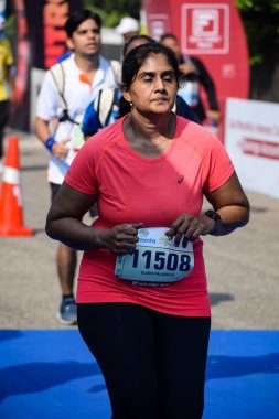 Yeni Delhi, Hindistan - 16 Ekim 2022 - Bitmek üzere olan maraton katılımcılarının bitiş çizgisini geçmek üzere olan Delhi Yarı Maratonu 2022