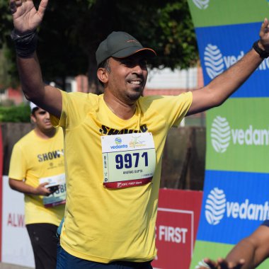 Yeni Delhi, Hindistan - 16 Ekim 2022 - Bitmek üzere olan maraton katılımcılarının bitiş çizgisini geçmek üzere olan Delhi Yarı Maratonu 2022