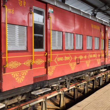 View of Toy train coach from the middle of railway track during daytime near Kalka railway station in India, Toy train coach view, Indian Railway junction, Heavy industry