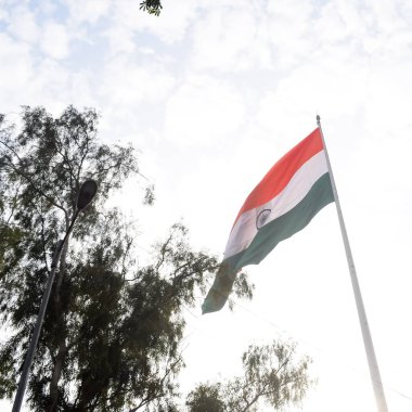 India flag flying high at Connaught Place with pride in blue sky, India flag fluttering, Indian Flag on Independence Day and Republic Day of India, tilt up shot, Waving Indian flag, Har Ghar Tiranga