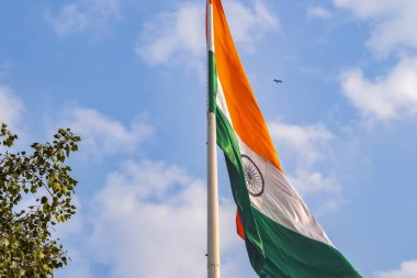 India flag flying high at Connaught Place with pride in blue sky, India flag fluttering, Indian Flag on Independence Day and Republic Day of India, tilt up shot, Waving Indian flag, Har Ghar Tiranga