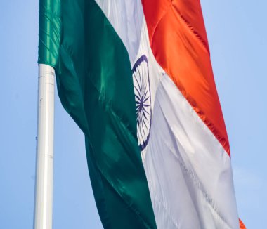 India flag flying high at Connaught Place with pride in blue sky, India flag fluttering, Indian Flag on Independence Day and Republic Day of India, tilt up shot, Waving Indian flag, Har Ghar Tiranga