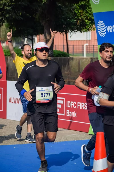 Yeni Delhi, Hindistan - 16 Ekim 2022 - Bitmek üzere olan maraton katılımcılarının bitiş çizgisini geçmek üzere olan Delhi Yarı Maratonu 2022