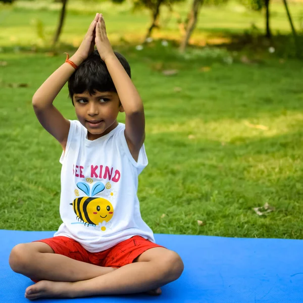 Sosyete parkında yoga pozu veren Asyalı zeki çocuk, çocuk yoga pozu. Yoga yapan küçük çocuk.