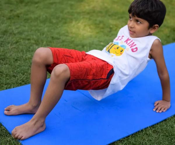 Sosyete parkında yoga pozu veren Asyalı zeki çocuk, çocuk yoga pozu. Yoga yapan küçük çocuk.