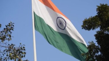India flag flying high at Connaught Place with pride in blue sky, India flag fluttering, Indian Flag on Independence Day and Republic Day of India, tilt up shot, Waving Indian flag, Har Ghar Tiranga
