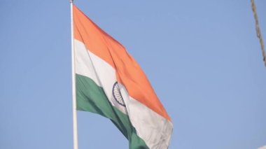 India flag flying high at Connaught Place with pride in blue sky, India flag fluttering, Indian Flag on Independence Day and Republic Day of India, tilt up shot, Waving Indian flag, Har Ghar Tiranga