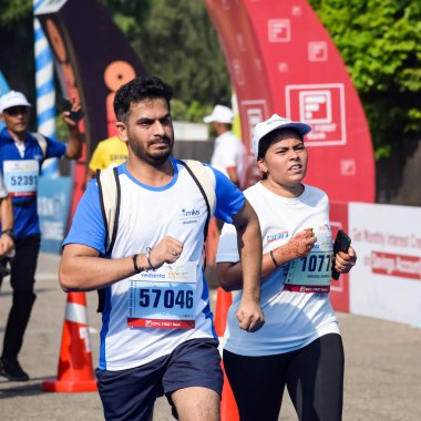 Yeni Delhi, Hindistan - 16 Ekim 2022 - Bitmek üzere olan maraton katılımcılarının bitiş çizgisini geçmek üzere olan Delhi Yarı Maratonu 2022