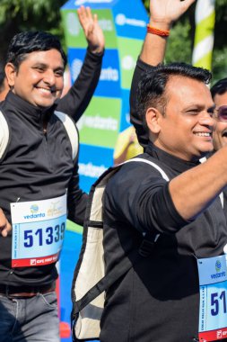 Yeni Delhi, Hindistan - 16 Ekim 2022 - Bitmek üzere olan maraton katılımcılarının bitiş çizgisini geçmek üzere olan Delhi Yarı Maratonu 2022