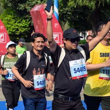 Yeni Delhi, Hindistan - 16 Ekim 2022 - Bitmek üzere olan maraton katılımcılarının bitiş çizgisini geçmek üzere olan Delhi Yarı Maratonu 2022