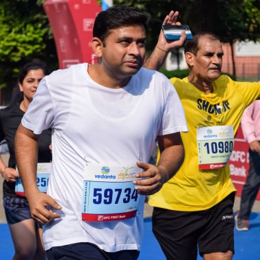 Yeni Delhi, Hindistan - 16 Ekim 2022 - Bitmek üzere olan maraton katılımcılarının bitiş çizgisini geçmek üzere olan Delhi Yarı Maratonu 2022