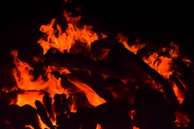 Siyah arka planda alevler, alev alev dokusu arka planda, çok güzel, ateş yanıyor, ateş odun ve inek gübresi ateşiyle yanıyor.