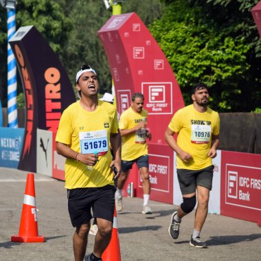 Yeni Delhi, Hindistan - 16 Ekim 2022 - Bitmek üzere olan maraton katılımcılarının bitiş çizgisini geçmek üzere olan Delhi Yarı Maratonu 2022