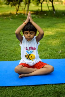 Sosyete parkında yoga pozu veren Asyalı zeki çocuk, çocuk yoga pozu. Yoga yapan küçük çocuk.