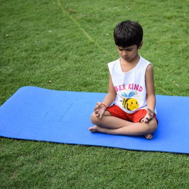 Sosyete parkında yoga pozu veren Asyalı zeki çocuk, çocuk yoga pozu. Yoga yapan küçük çocuk.