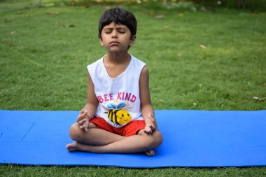 Sosyete parkında yoga pozu veren Asyalı zeki çocuk, çocuk yoga pozu. Yoga yapan küçük çocuk.