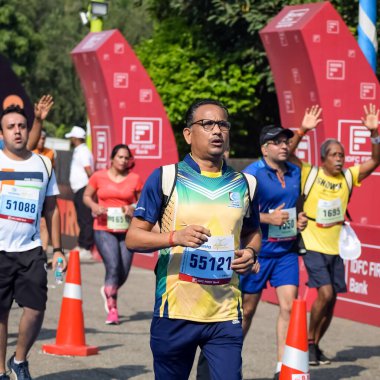 Yeni Delhi, Hindistan - 16 Ekim 2022 - Bitmek üzere olan maraton katılımcılarının bitiş çizgisini geçmek üzere olan Delhi Yarı Maratonu 2022