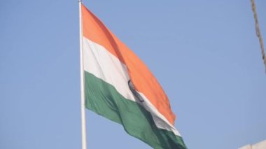 India flag flying high at Connaught Place with pride in blue sky, India flag fluttering, Indian Flag on Independence Day and Republic Day of India, tilt up shot, Waving Indian flag, Har Ghar Tiranga