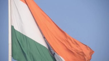 India flag flying high at Connaught Place with pride in blue sky, India flag fluttering, Indian Flag on Independence Day and Republic Day of India, tilt up shot, Waving Indian flag, Har Ghar Tiranga