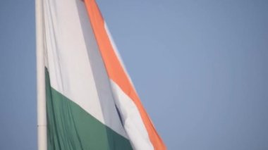 India flag flying high at Connaught Place with pride in blue sky, India flag fluttering, Indian Flag on Independence Day and Republic Day of India, tilt up shot, Waving Indian flag, Har Ghar Tiranga
