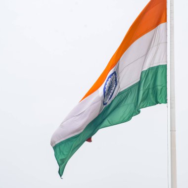 India flag flying high at Connaught Place with pride in blue sky, India flag fluttering, Indian Flag on Independence Day and Republic Day of India, tilt up shot, Waving Indian flag, Har Ghar Tiranga