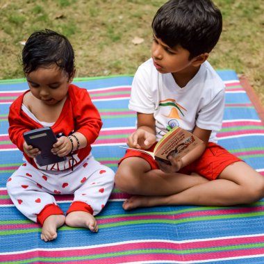 Sosyete parkında iki mutlu çocuk, birlikte mutlu gülümseyen mutlu Asyalı kardeşler. Kardeşler yazın dışarıda oynar, en iyi arkadaşlar. Küçük oğlan mutlu erkek kardeşiyle bahçede oynuyor.
