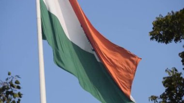 India flag flying high at Connaught Place with pride in blue sky, India flag fluttering, Indian Flag on Independence Day and Republic Day of India, tilt up shot, Waving Indian flag, Har Ghar Tiranga