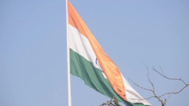 India flag flying high at Connaught Place with pride in blue sky, India flag fluttering, Indian Flag on Independence Day and Republic Day of India, tilt up shot, Waving Indian flag, Har Ghar Tiranga