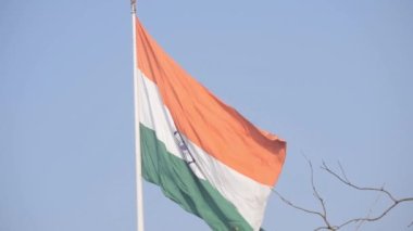 India flag flying high at Connaught Place with pride in blue sky, India flag fluttering, Indian Flag on Independence Day and Republic Day of India, tilt up shot, Waving Indian flag, Har Ghar Tiranga