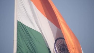 India flag flying high at Connaught Place with pride in blue sky, India flag fluttering, Indian Flag on Independence Day and Republic Day of India, tilt up shot, Waving Indian flag, Har Ghar Tiranga