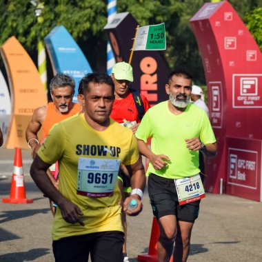 Yeni Delhi, Hindistan - 16 Ekim 2022 - Bitmek üzere olan maraton katılımcılarının bitiş çizgisini geçmek üzere olan Delhi Yarı Maratonu 2022