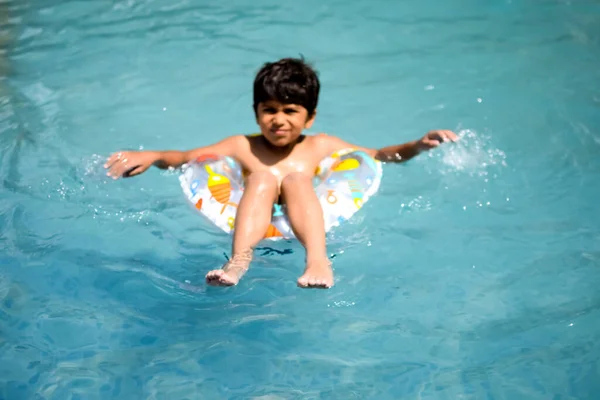 快乐的印度男孩在游泳池里游泳 孩子在炎炎夏日带着泳衣和空气管子 孩子们在大游泳池里 — 图库照片