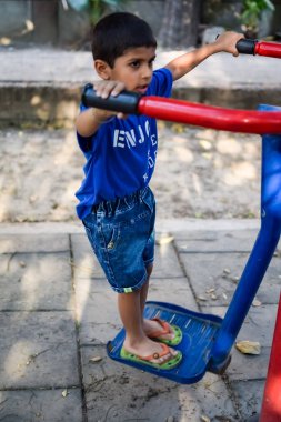 Asyalı çocuk sabah vakti sosyete parkında rutin egzersiz yapıyor. Kendini hayat boyu zinde tutmak için şirin bir çocuk egzersizi ve spor salonu. Çocukların açık hava egzersizleri.