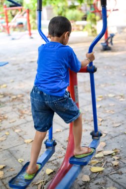 Asyalı çocuk sabah vakti sosyete parkında rutin egzersiz yapıyor. Kendini hayat boyu zinde tutmak için şirin bir çocuk egzersizi ve spor salonu. Çocukların açık hava egzersizleri.