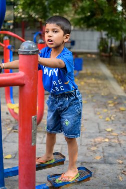 Asyalı çocuk sabah vakti sosyete parkında rutin egzersiz yapıyor. Kendini hayat boyu zinde tutmak için şirin bir çocuk egzersizi ve spor salonu. Çocukların açık hava egzersizleri.
