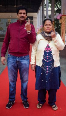 New Delhi, India - December 04 2022 - Unidentified people showing their ink-marked fingers after casting votes in front of polling booth of east Delhi area for MCD local body Elections 2022