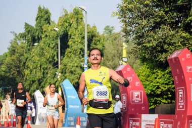 Yeni Delhi, Hindistan - 16 Ekim 2022 - Bitmek üzere olan maraton katılımcılarının bitiş çizgisini geçmek üzere olan Delhi Yarı Maratonu 2022