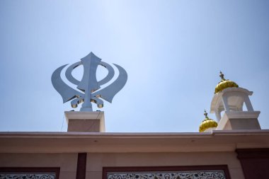 Gurudwara girişinde Khanda Sikh kutsal dini sembolü parlak mavi gökyüzü görüntüsüyle Chandni Chowk 'ta, Eski Delhi' deki Kızıl Kale 'nin karşısındaki Sis Ganj Sahib Gurudwara' da çekildi.